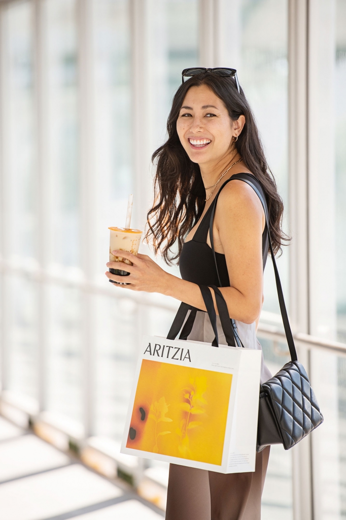 A young woman with a shopping bag and a bubble tea