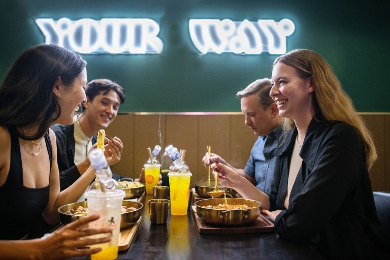 A group of four young urban professionals sitting around a restaurant table